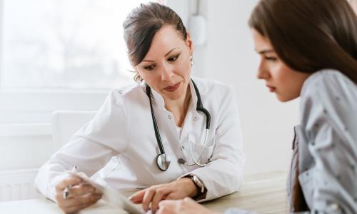 Women's Health Nurse Practitioner Badge Banner Women's health nurse practitioner referencing test results with patient
